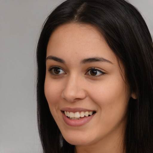 Joyful latino young-adult female with long  brown hair and brown eyes