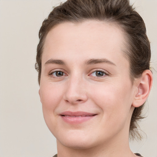 Joyful white young-adult female with short  brown hair and grey eyes