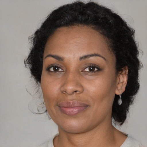 Joyful black adult female with medium  black hair and brown eyes