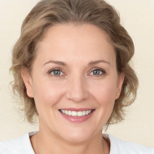 Joyful white adult female with medium  brown hair and grey eyes