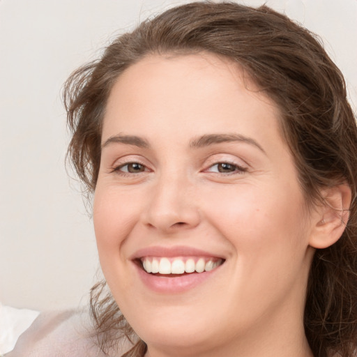 Joyful white young-adult female with medium  brown hair and green eyes