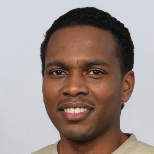 Joyful black young-adult male with short  black hair and brown eyes