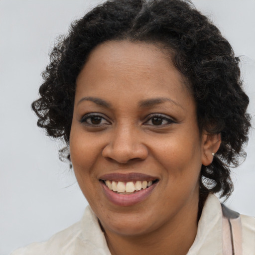 Joyful black young-adult female with long  brown hair and brown eyes