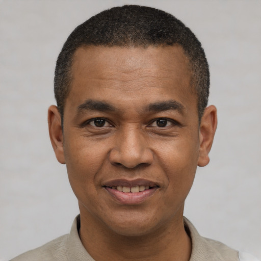 Joyful black young-adult male with short  black hair and brown eyes