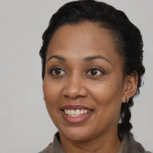 Joyful black adult female with short  brown hair and brown eyes