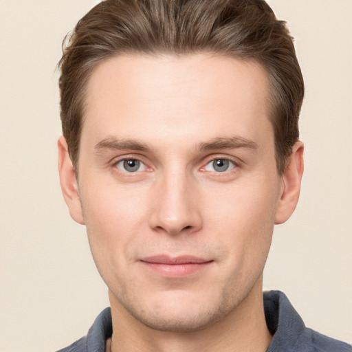 Joyful white young-adult male with short  brown hair and grey eyes