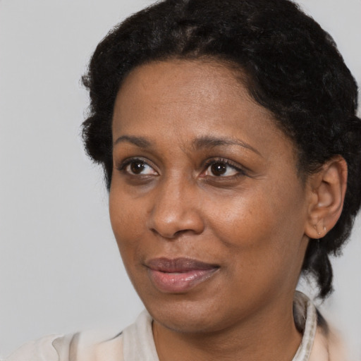 Joyful black adult female with short  black hair and brown eyes