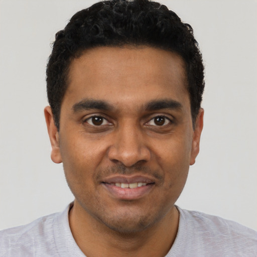 Joyful black young-adult male with short  black hair and brown eyes