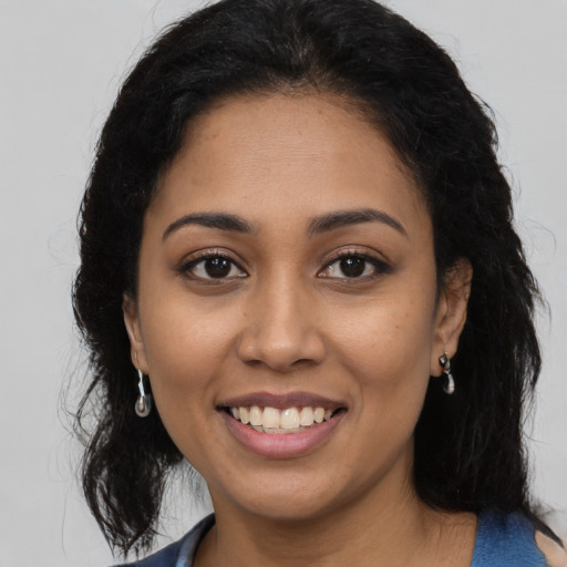 Joyful latino young-adult female with long  brown hair and brown eyes