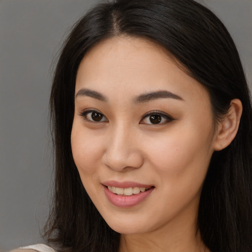 Joyful asian young-adult female with long  brown hair and brown eyes