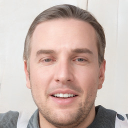 Joyful white young-adult male with short  brown hair and grey eyes