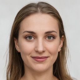 Joyful white young-adult female with long  brown hair and green eyes