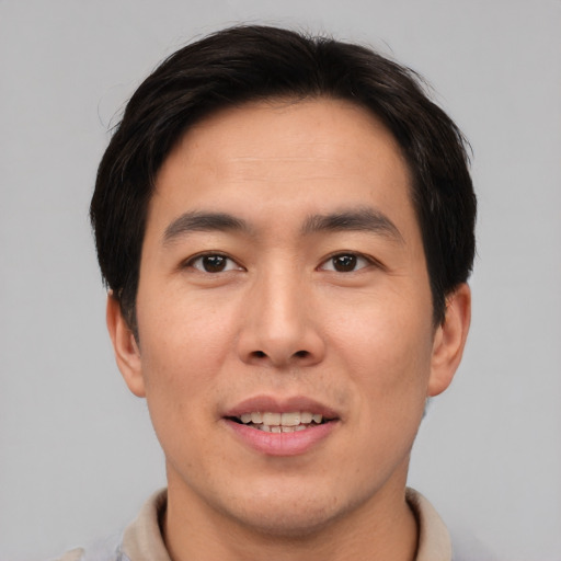 Joyful asian young-adult male with short  brown hair and brown eyes