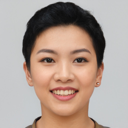 Joyful asian young-adult female with short  black hair and brown eyes