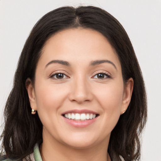 Joyful white young-adult female with long  brown hair and brown eyes