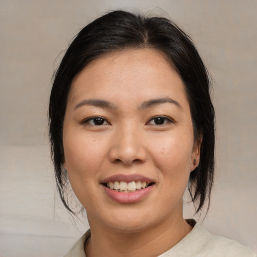 Joyful asian young-adult female with medium  brown hair and brown eyes