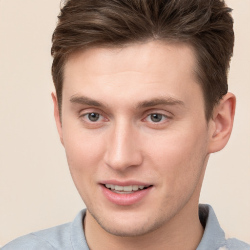 Joyful white young-adult male with short  brown hair and grey eyes