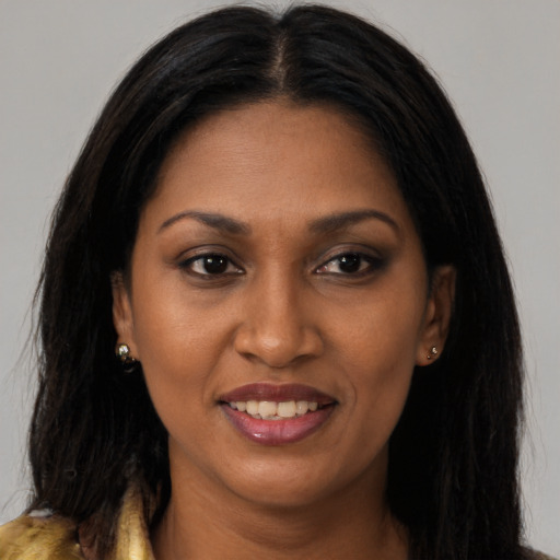 Joyful black young-adult female with long  brown hair and brown eyes