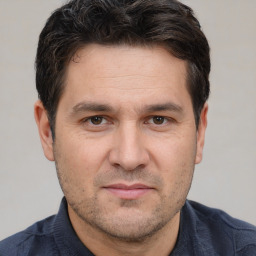 Joyful white adult male with short  brown hair and brown eyes