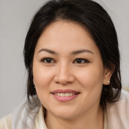 Joyful asian young-adult female with medium  brown hair and brown eyes