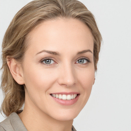 Joyful white young-adult female with medium  brown hair and grey eyes