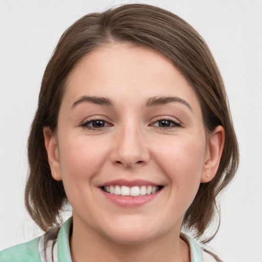 Joyful white young-adult female with medium  brown hair and grey eyes