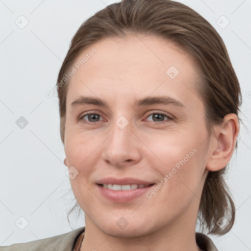 Joyful white young-adult female with medium  brown hair and grey eyes