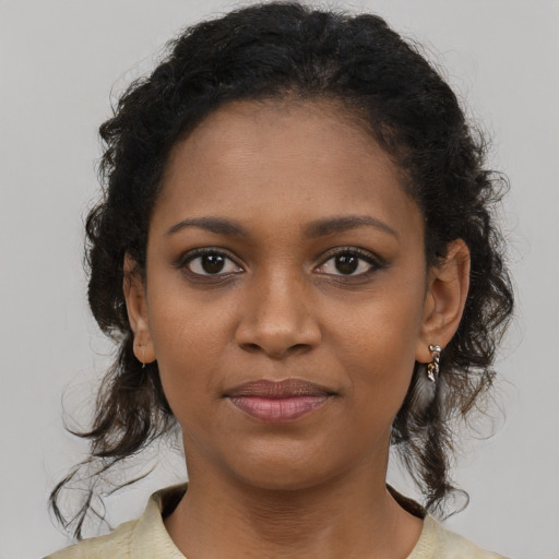 Joyful black young-adult female with long  brown hair and brown eyes