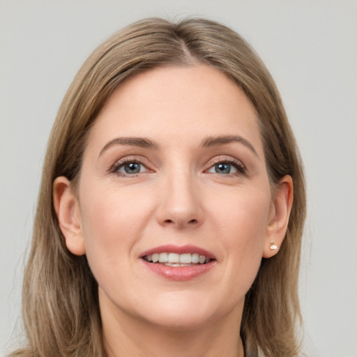 Joyful white young-adult female with long  brown hair and grey eyes