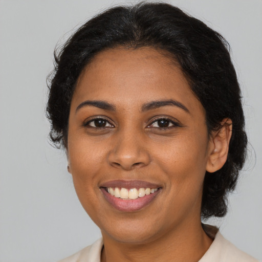 Joyful black young-adult female with medium  brown hair and brown eyes