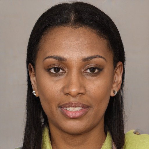 Joyful black young-adult female with long  brown hair and brown eyes