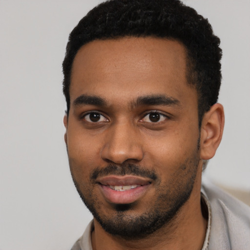 Joyful black young-adult male with short  black hair and brown eyes