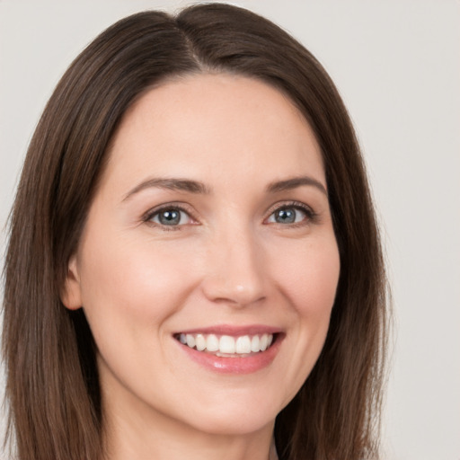 Joyful white young-adult female with long  brown hair and brown eyes