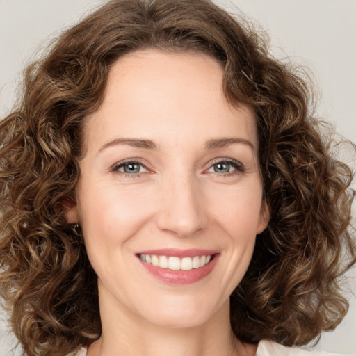 Joyful white young-adult female with medium  brown hair and green eyes