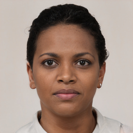 Joyful black young-adult female with short  black hair and brown eyes