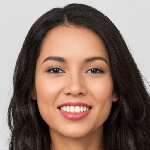 Joyful latino young-adult female with long  brown hair and brown eyes