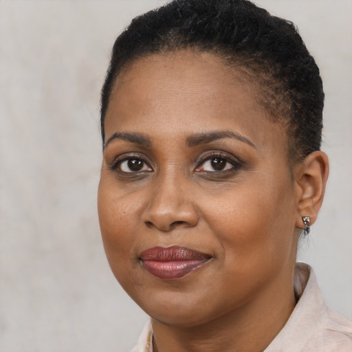 Joyful black young-adult female with short  brown hair and brown eyes
