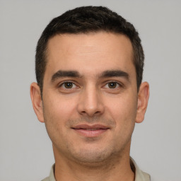 Joyful white young-adult male with short  brown hair and brown eyes
