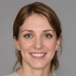 Joyful white young-adult female with medium  brown hair and blue eyes