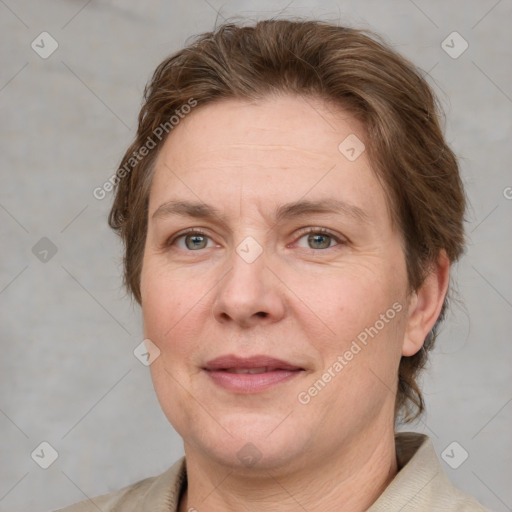 Joyful white adult female with short  brown hair and blue eyes