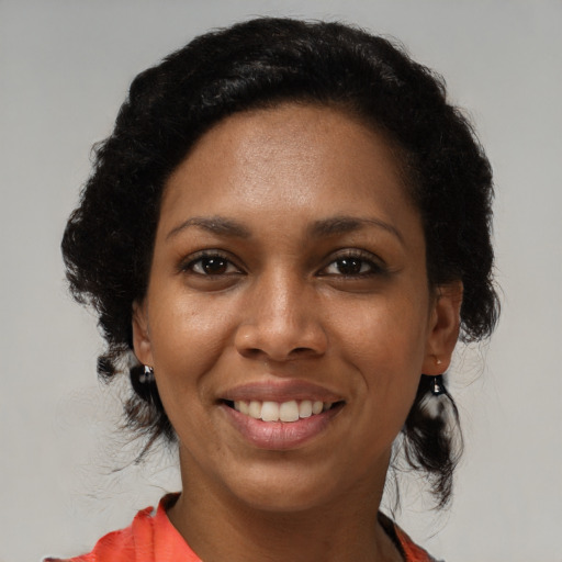 Joyful black young-adult female with medium  black hair and brown eyes