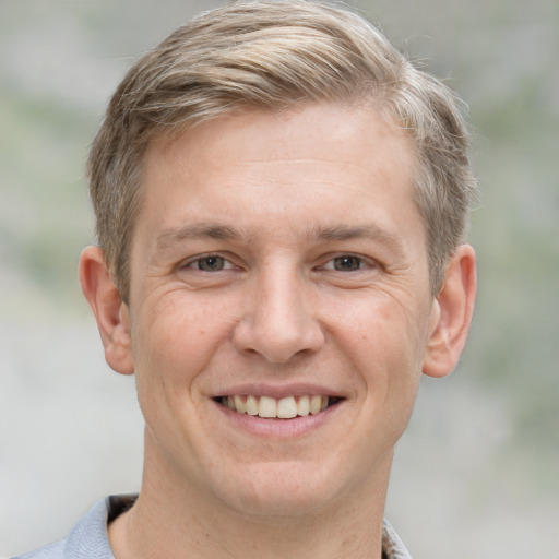 Joyful white adult male with short  brown hair and grey eyes