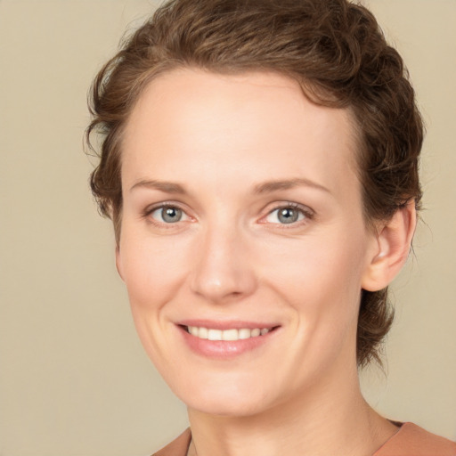 Joyful white young-adult female with short  brown hair and green eyes