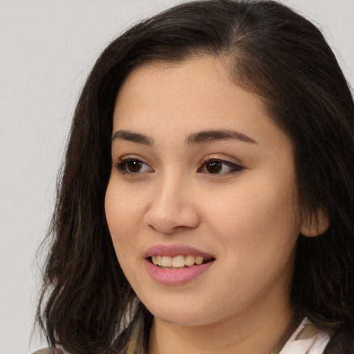 Joyful asian young-adult female with long  brown hair and brown eyes