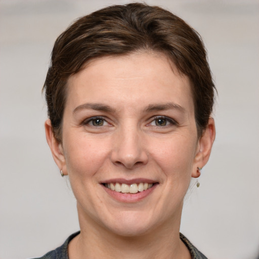 Joyful white young-adult female with short  brown hair and grey eyes