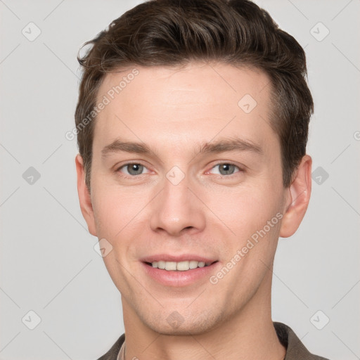 Joyful white young-adult male with short  brown hair and grey eyes