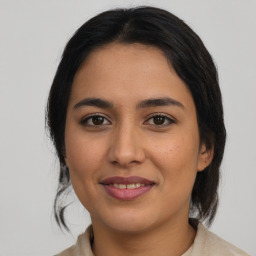 Joyful latino young-adult female with medium  brown hair and brown eyes