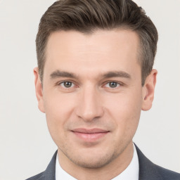 Joyful white young-adult male with short  brown hair and grey eyes