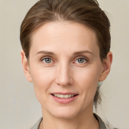 Joyful white young-adult female with short  brown hair and grey eyes