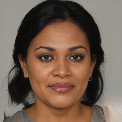 Joyful black young-adult female with medium  brown hair and brown eyes